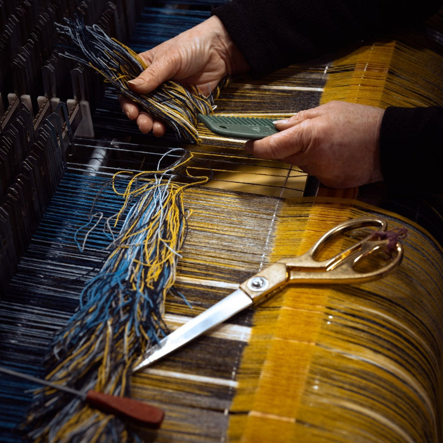 Image of Loom with new warp being tied in linked to Meet the Team page